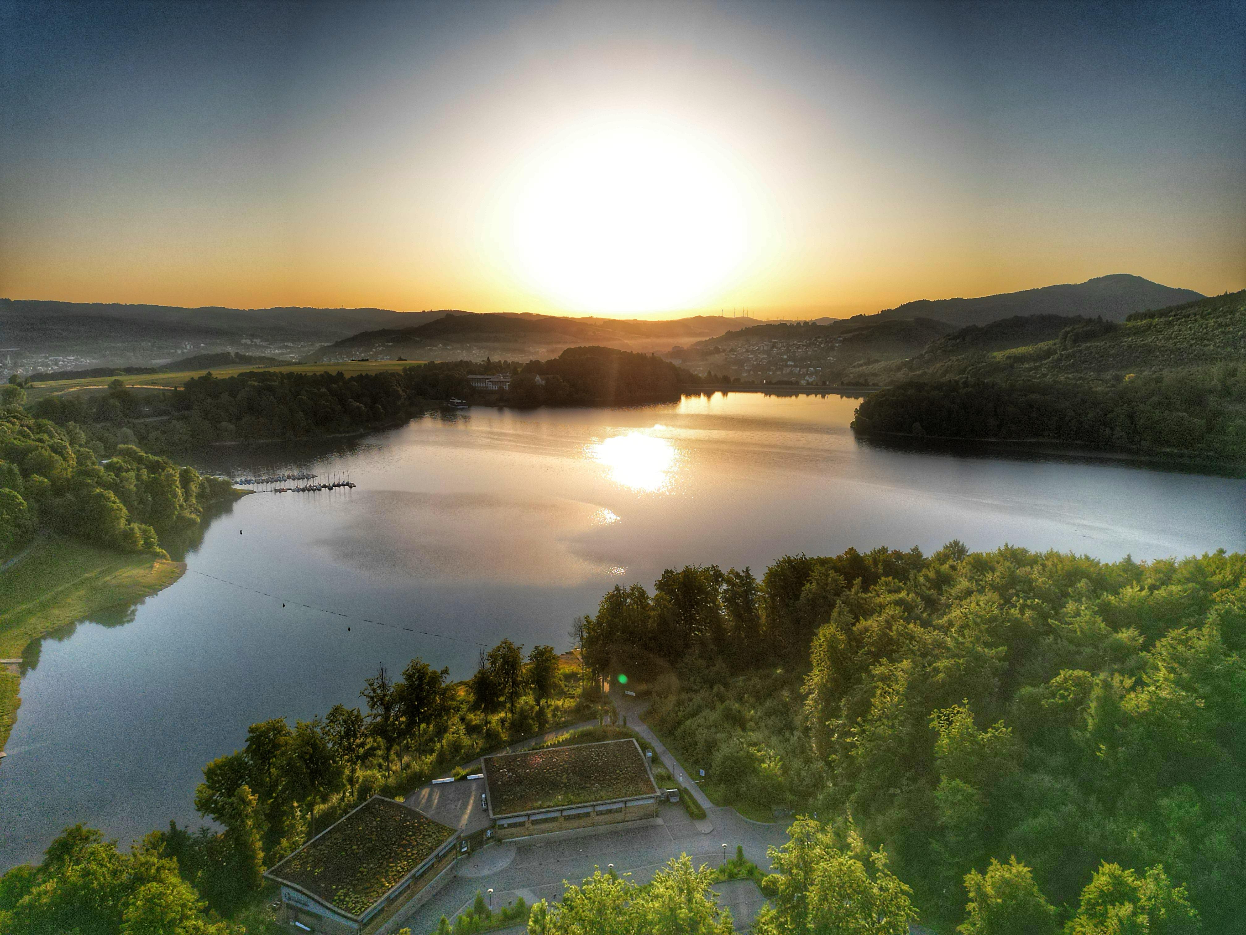 Ein See, umgeben von Bäumen und Gebäuden.